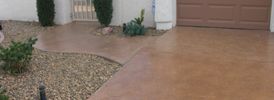 poured concrete driveway and sidewalk with gravel landscaping